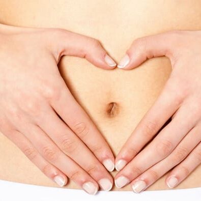 woman making heart shape over her tummy
